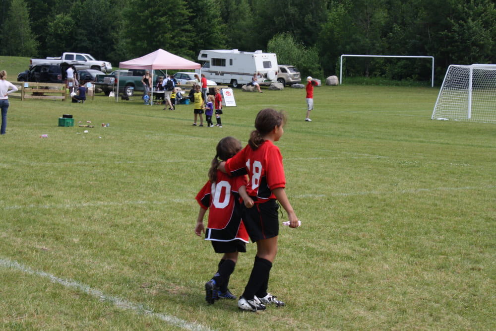 little girls walking across soccer pitch