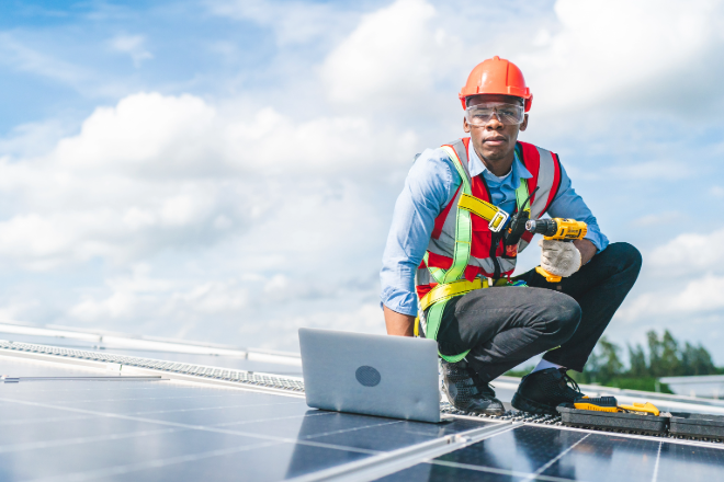 man with hard hat on solar panels